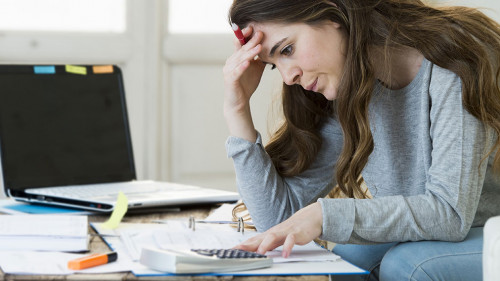worried woman suffering stress doing domestic accounting paperwo