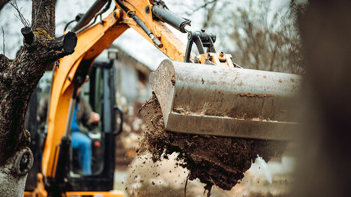 Worker using excavator and bulldozer for landscaping works