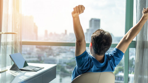 Business achievement concept with happy businessman relaxing in