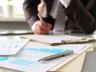 Silver pen lie at important paper on table in office