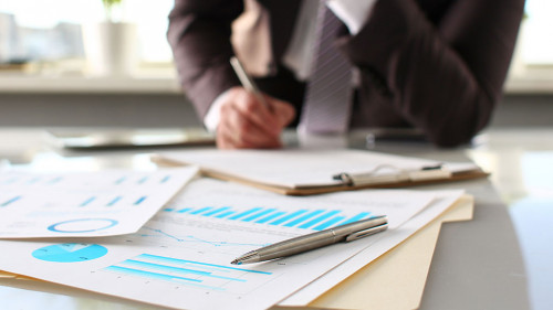 Silver pen lie at important paper on table in office