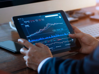 Businessman checking stock market on digital tablet and a deskto