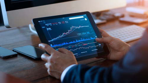 Businessman checking stock market on digital tablet and a deskto