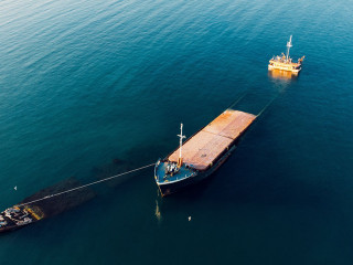 Sunken cargo ship near Crimean seaside, aerial view from drone.