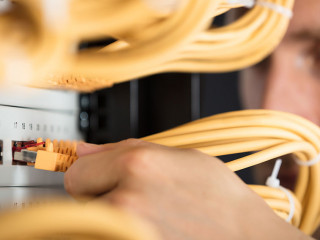 Engineer Plugging Cables Into Server