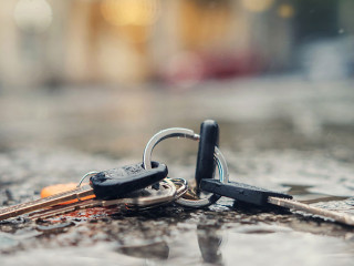 Set of lost keys on the ring on wet ground on the street