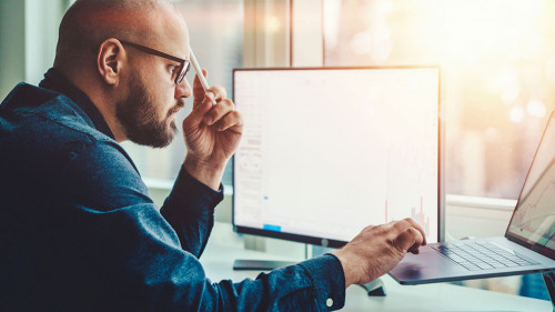 Professional male currency trader making research in financial m