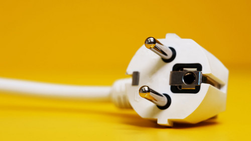 AC power plug on yellow background.