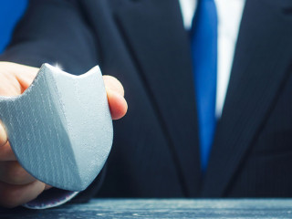 A man holds a protection shield in his hand. Safety, life and property insurance. Security personnel, maintaining law and order. Lawyer defends the rights and innocence. Protectionism, defense