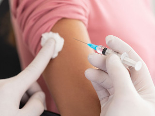 Male doctor doing vaccination to young woman