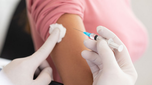 Male doctor doing vaccination to young woman