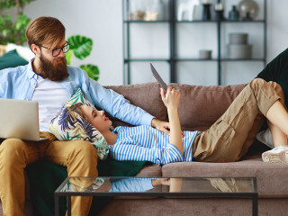 happy couple relaxing at home with laptop and tablet