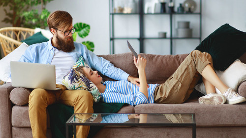 happy couple relaxing at home with laptop and tablet