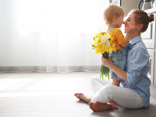 happy mother's day! baby son gives flowersfor  mother on holiday
