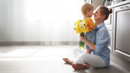 happy mother's day! baby son gives flowersfor mother on holiday