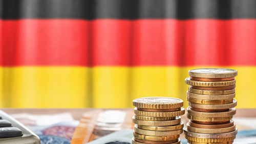 Geldscheine und Münzen vor der Nationalflagge Deutschlands