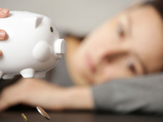 Unhappy woman shaking an empty piggy bank