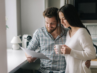 Attractive young married couple ouple studying mortgage documents together