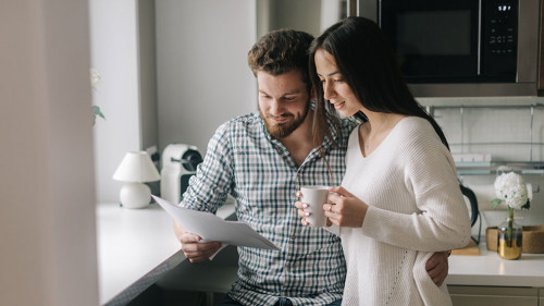 Attractive young married couple ouple studying mortgage documents together