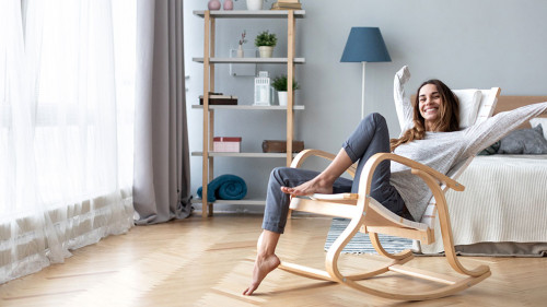 Happy woman resting comfortably sitting on modern chair in the l