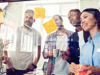 Business people meeting at office and use post it notes to share idea. Brainstorming concept. Sticky note on glass wall