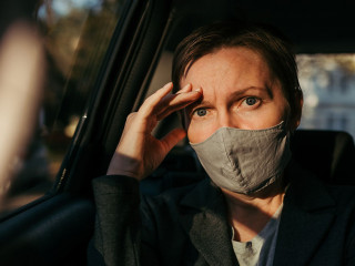 Anxious businesswoman sitting inside of the car and looking at c