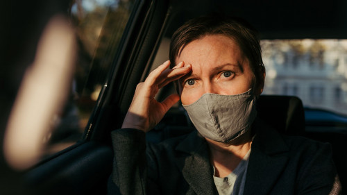 Anxious businesswoman sitting inside of the car and looking at c
