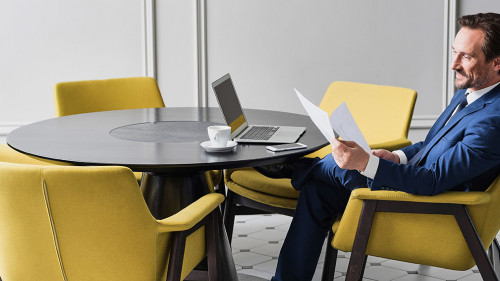 Happy male manager working with papers in cozy office