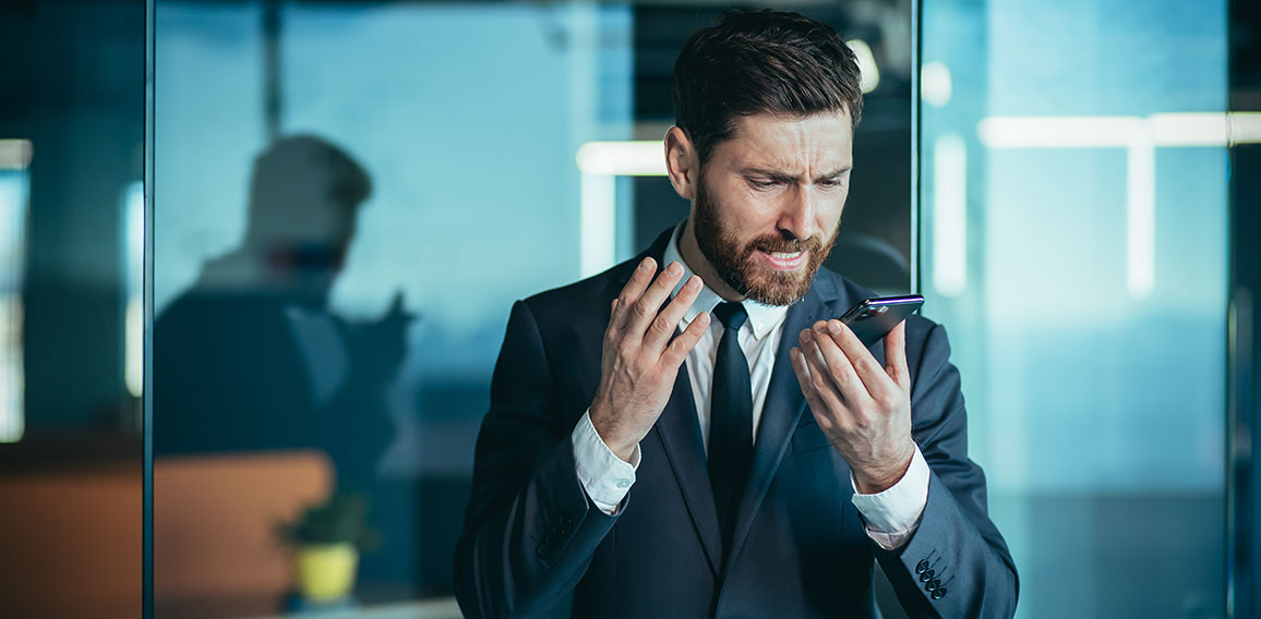 Angry and nervous boss shouting into phone, during phone conversation with employee, businessman in modern office with phone