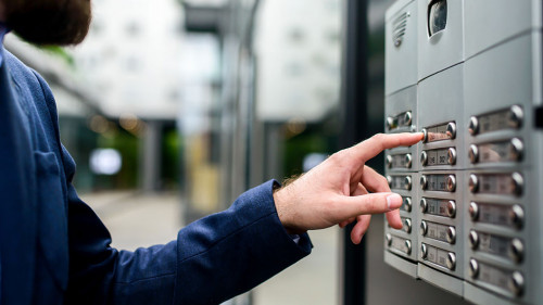 Man pushing the button and talking on the intercom