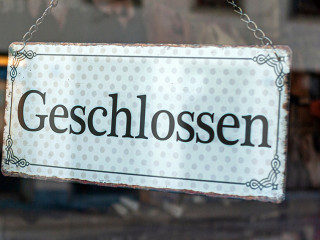 Schaufenster von Ladengeschäft mit Schild „Geschlossen“, in