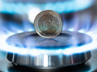 Burning natural gas and one euro coin on gas hob.