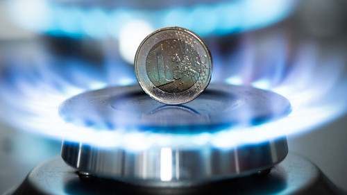 Burning natural gas and one euro coin on gas hob.