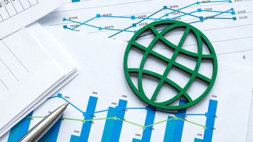 ESG concept. The green symbol of the globe lies on financial papers.