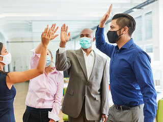 Business Team mit Mund-Nasen-Schutz beim High Five