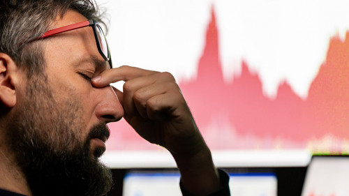 Depressed businessman in front of computer with graph of unsuccessful business on the screen