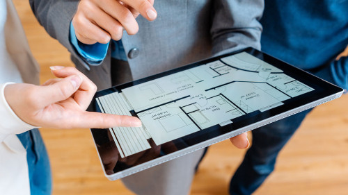 Realtor explaining floor plan to couple buying a house