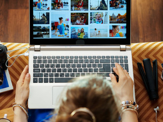 woman looks at image while transferring photos from DSLR camera