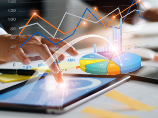 Businessman using tablet and laptop analyzing sales data and eco