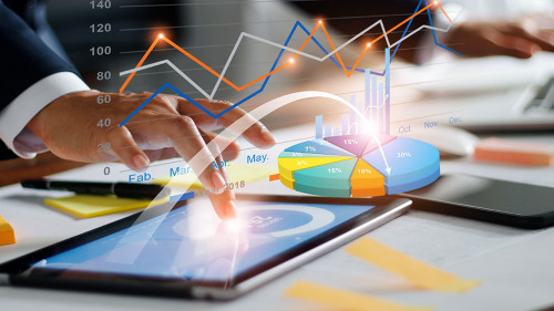 Businessman using tablet and laptop analyzing sales data and eco