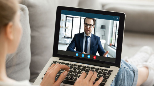 Computer screen monitor view over female shoulder