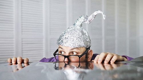 Bearded funny man in a cap of aluminum foil. Concept art phobias