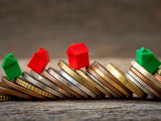 Pile of coins and miniature house models