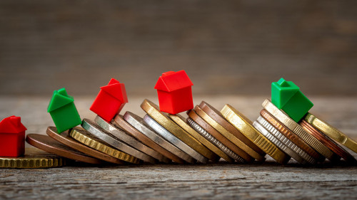 Pile of coins and miniature house models