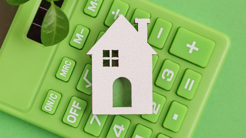 Responsible Lending. Sustainability credit. Green Calculator, white Home, Leaf on green background.