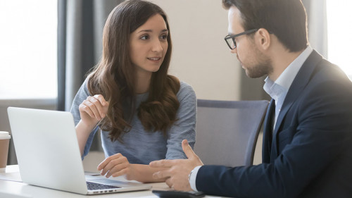Female manager broker consulting client in corporate office with laptop