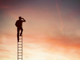 Businessman looks far for new business with binocular