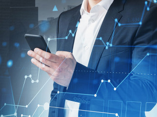 Man with smartphone in night city and graph