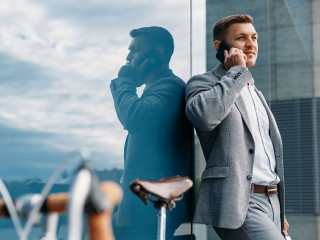 Businessman talking by mobile phone at the bicycle