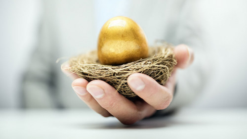 Retirement savings golden nest egg in businessman hand